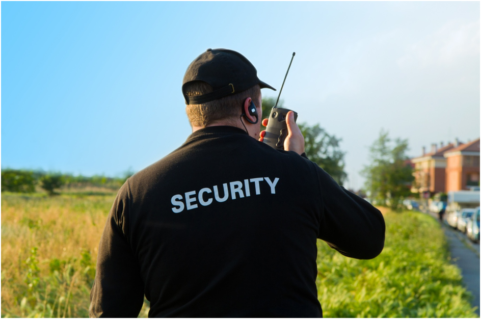 A man in black shirt holding a walkie talkie.