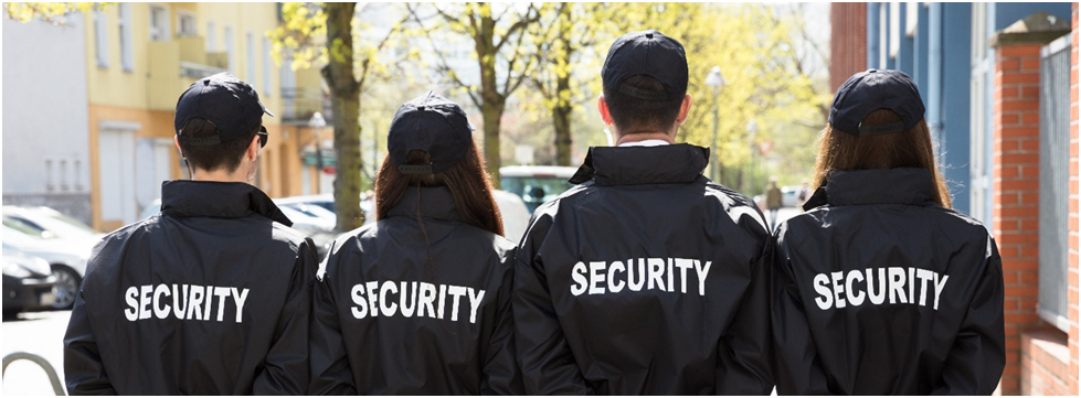 Two people in black jackets and hats standing next to each other.