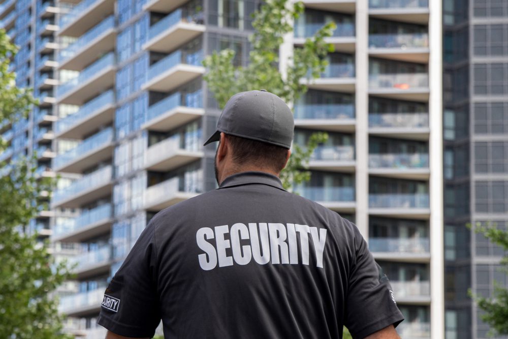 A security guard standing in front of some buildings