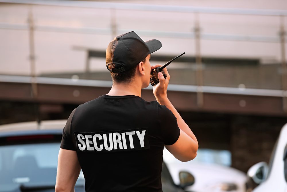 A man in black shirt holding a walkie talkie.